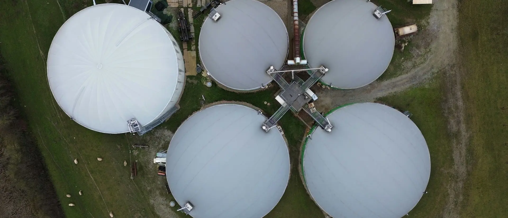 En biogasanläggning från ovan. Silos syns uppifrån. 