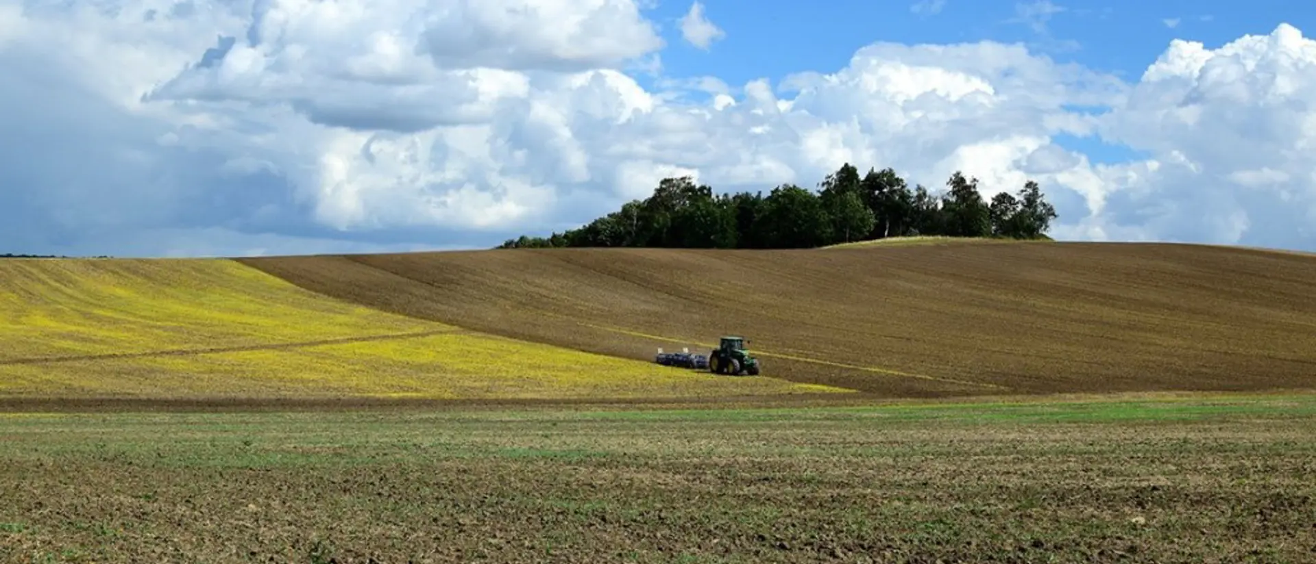 En traktor kör över fälten på avstånd.